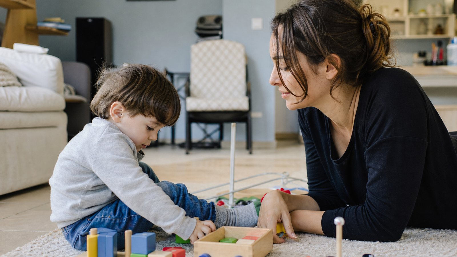 Jeune enfant jouant à la maison avec la personne qui le garde au quotidien